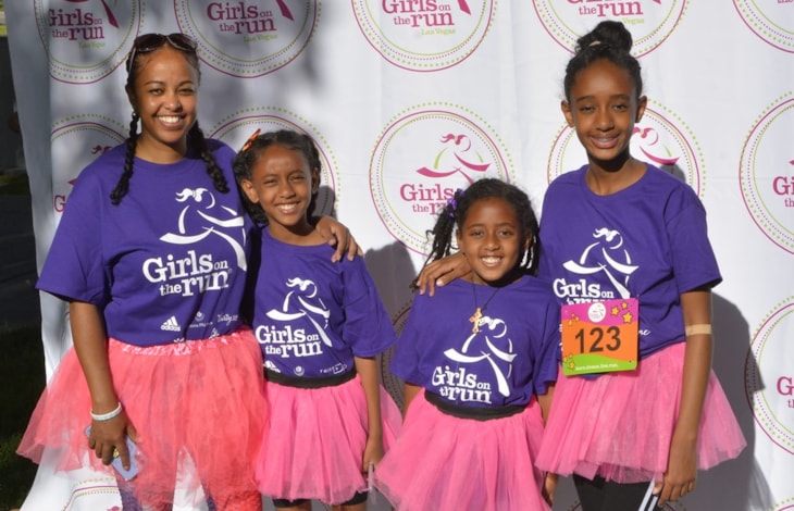 Three GOTR Girls and their Coach in purple shirts and pink tutus